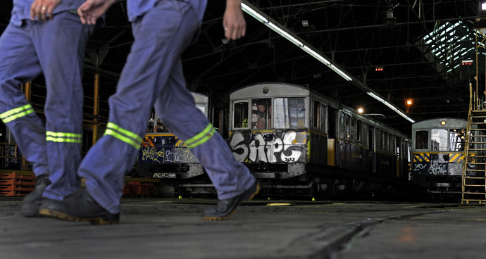 Workers walk next to the historic wagons of La Brugeoise at the garage El Polvorin, in the neighborhood of Caballito, Buenos Aires.(AFP Photo / Alejandro Pagni)